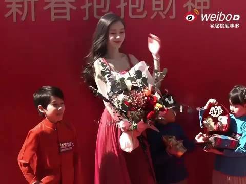 女子举花为孩童挡太阳显细腻善良