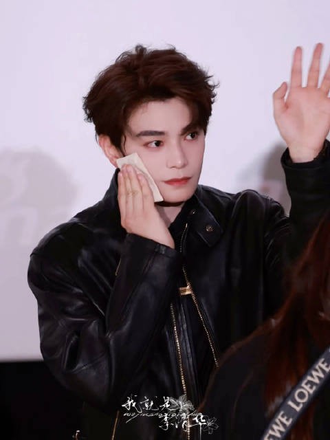 男孩边擦汗边打招呼，皮衣穿搭展现男友力