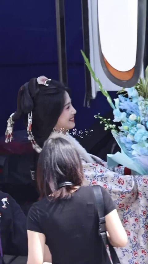 在剧组收到一大束花的卢昱晓，单手扛花可爱的喂